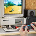 Joy-Con 2 controllers charging beside a retro gaming setup